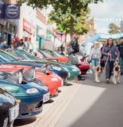 Banner photo of a lady in 1950's costume alongside a Chevy classic car at the Hinckley BID Motorshow